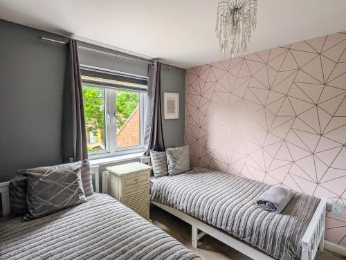 a bedroom with two beds and a window at Chilton Charm in Chilton