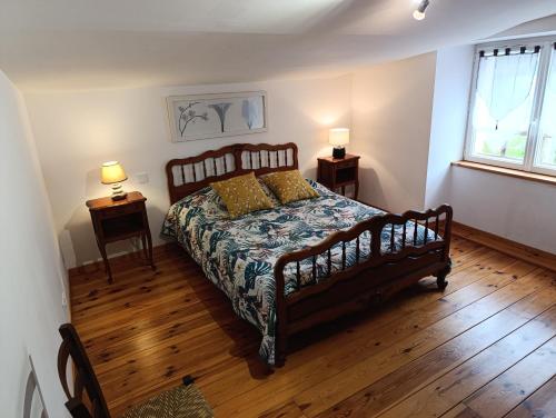 a bedroom with a large bed and two night stands at Gîtes de la Bibudière in Le Boupère