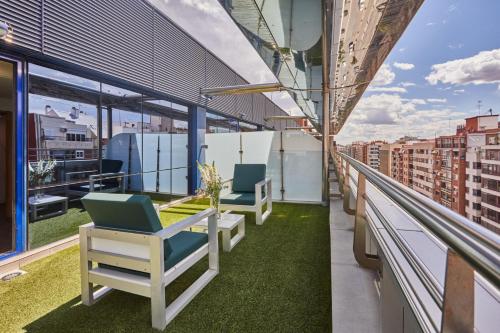 a balcony with chairs and grass on a building at Silken Puerta Valencia in Valencia
