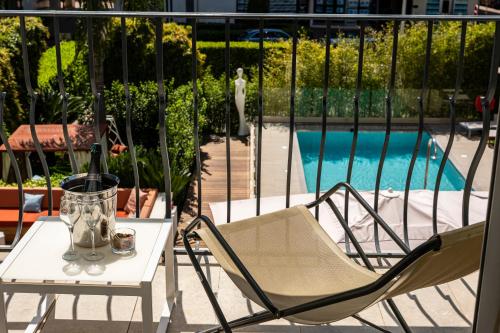 d'une table et de chaises sur un balcon avec piscine. dans l'établissement Hôtel Le Canberra, à Cannes