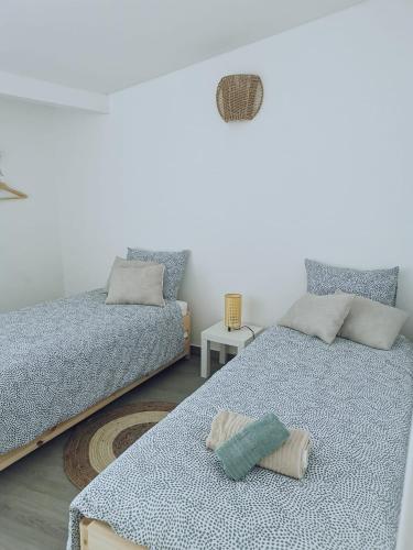 a bedroom with two beds and a table at Old Town House in Lourinhã