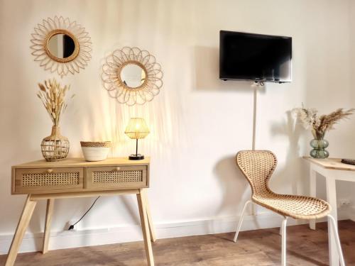 a room with a table and a chair and a mirror at L'évasion Marine à la plage 2P in Houlgate