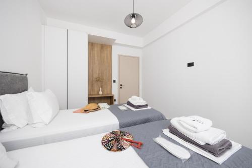 two beds in a white room with towels on the bed at Villa 13 Zendo in Kolymbia