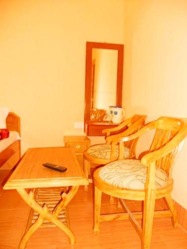 a room with two chairs and a table and a mirror at Guptkashi Palace in Gupta Kāshi