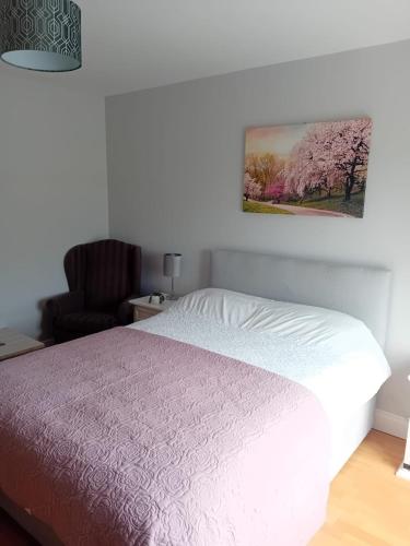 a bedroom with a white bed and a chair at An Charraig Ban on the wild Atlantic way F94WT02 in Ardara