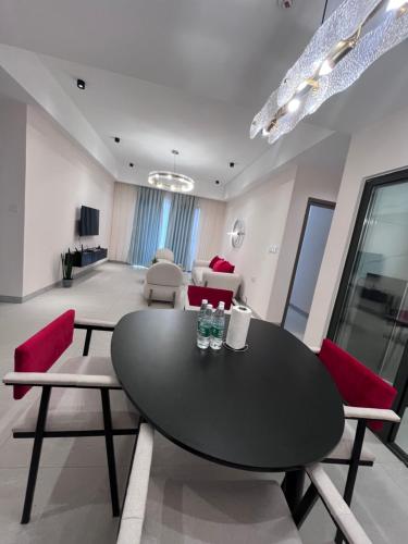 a living room with a black table and red chairs at Kigali Greenland Serviced Apartments in Kigali