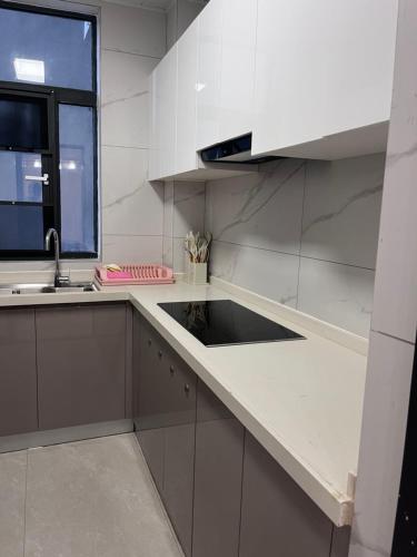 a white kitchen with a sink and a window at Kigali Greenland Serviced Apartments in Kigali