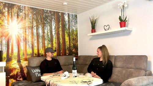 two women sitting on a couch with a table at Ferienhaus für drei Personen mit Terrasse in Friedrichroda