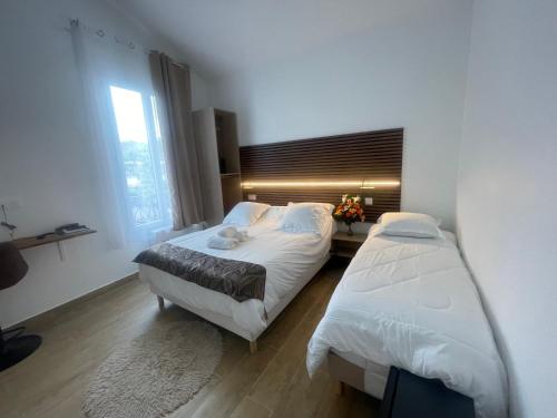 a bedroom with two beds and a window at Hôtel du Parc Canal - Stade de France in Saint-Denis