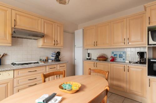 Una cocina con gabinetes de madera y una mesa de madera. en Fantasia - Parking - Pet friendly, en Mindin