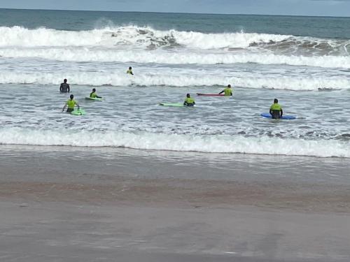 a group of people in the ocean with surfboards at Etxeberria in Zarautz