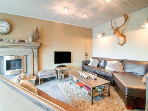 a living room with a couch and a fireplace at Great holiday home in Bastogne with sauna in Le Parque