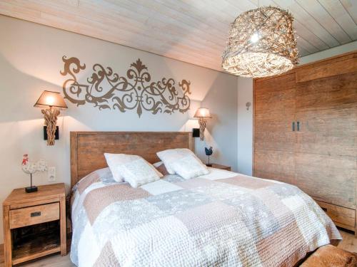 a bedroom with a large bed and a chandelier at Great holiday home in Bastogne with sauna in Le Parque