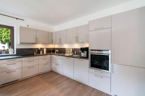 a white kitchen with white cabinets and appliances at Haus Katharina 2 in Inzell