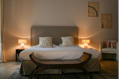 a bedroom with a bed with two lamps and a chair at Mas des Comtes de Provence in Tarascon