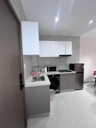 a kitchen with white cabinets and a sink at Kigali Greenland Serviced Apartments in Kigali