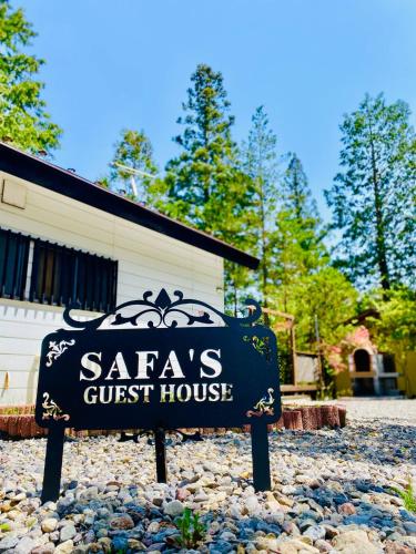 a sign for a guest house in front of a building at Safa's Guest House in Nikko