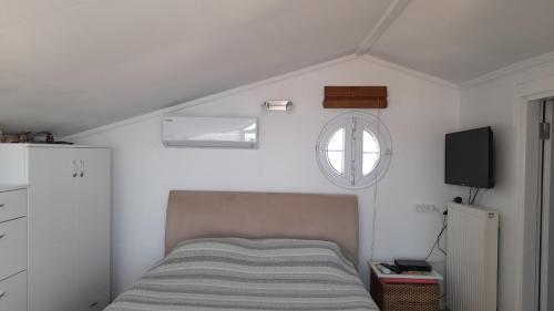 a small bedroom with a bed and a window at aj konukevi müstakil ev dört odalı in Ayvalık