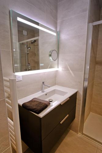 une salle de bain avec un lavabo et un miroir dans l'établissement T2 neuf haut standing Pornichet proche mer, à Pornichet