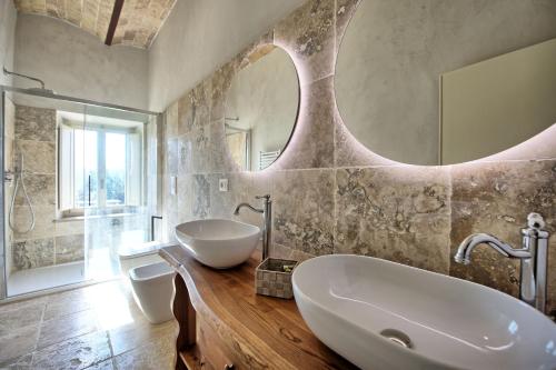 a bathroom with a tub and a sink and a mirror at Borgo Ariano near Volterra by PosarelliVillas in SantʼAnastasio