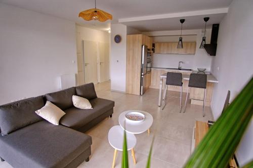 un salon avec un canapé et une cuisine dans l'établissement T2 neuf haut standing Pornichet proche mer, à Pornichet