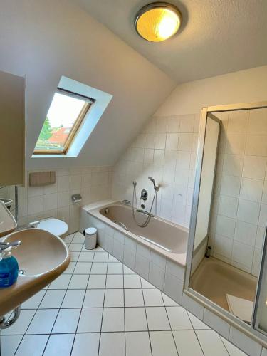 a bathroom with a bath tub and a sink at Holiday Rügen Putbus in Putbus
