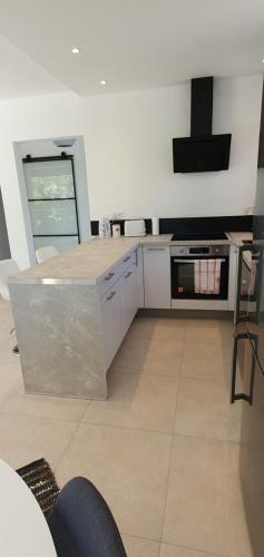 une cuisine avec des armoires blanches et un four à plaques de cuisson dans l'établissement Villa Saint Michel, à Saint-Félix-de-Lodez