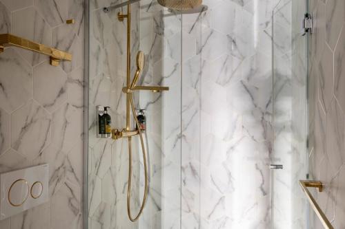 a bathroom with a shower with white marble at Hôtel Maxim Folies in Paris