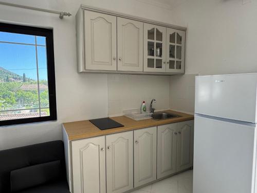 a kitchen with a white refrigerator and a window at Koala Place in Vasiliki