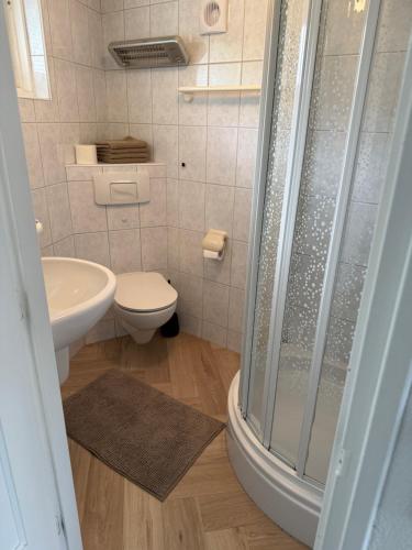 a bathroom with a shower and a toilet and a sink at Stillwater Lodge De Rijd in Nieuwe-Niedorp
