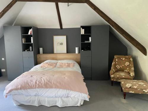 une chambre avec un grand lit et une chaise dans l'établissement Grande Capitainerie en bord de Rance, à Plouër-sur-Rance