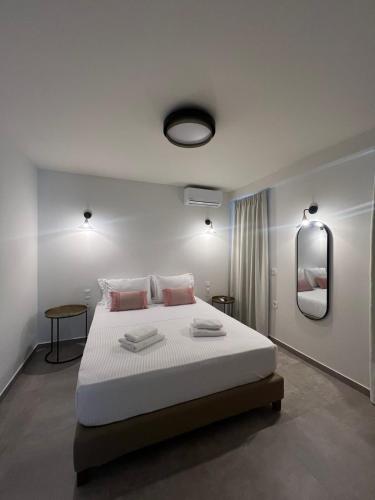 a bedroom with a large white bed with two pillows at ALTHEA luxury suites and apartments in Plataria