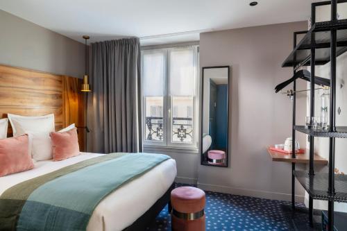 a hotel room with a bed and a window at Hôtel Maxim Folies in Paris