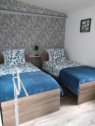 deux lits côte à côte dans une chambre dans l'établissement Gîte Les Oeillets, à Beauchamps