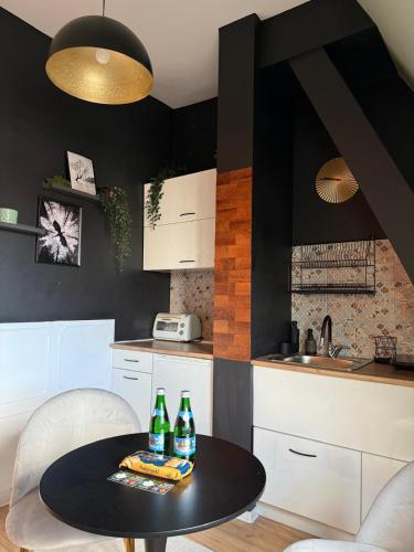 a kitchen with a table and two bottles on it at Apartamenty w centrum Wawel & Smok AC Progres in Toruń