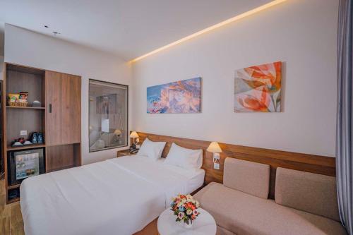 a hotel room with a bed and a couch at RosaLie Quảng Bình Hotel in Dong Hoi