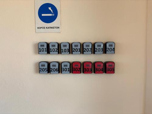 a row of clocks on a wall with a sign at Delta Apartments in Pherrai