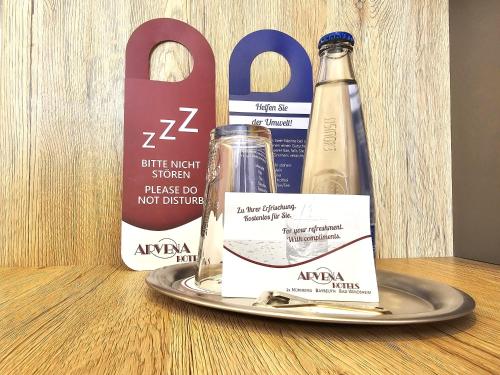 a bottle of wine on a table next to a pair of scissors at Arvena Park Hotel in Nürnberg