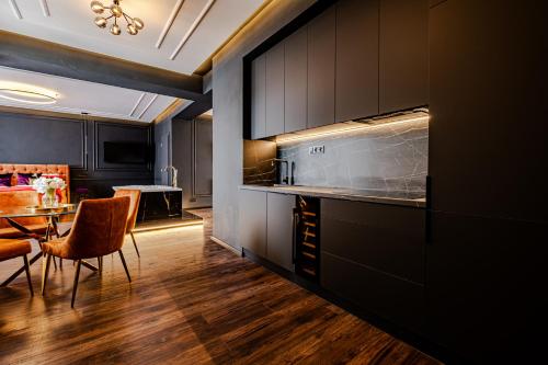 a kitchen with black cabinets and a table and chairs at Merido Apartment in Nitra