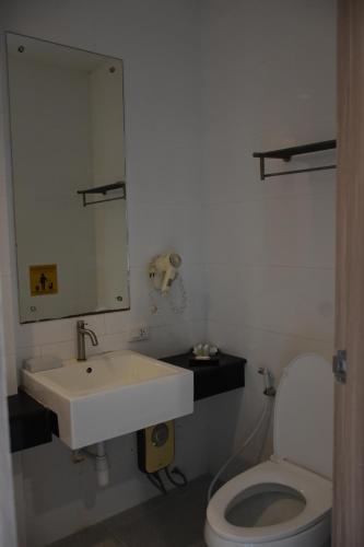 a bathroom with a sink and a toilet at Lae Lay Suite in Ban Karon