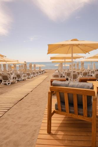 a row of chairs and umbrellas on a beach at A Suite Side in Side