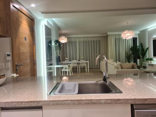 a kitchen with a sink and a living room at El Gouna - 3 Bedroom - Rooftop-Pool - Ancient Hill in Hurghada