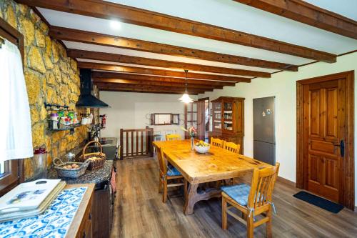 a kitchen with a wooden table and a stone wall at El Balcón Del Profesor By Silastur in Cereceda