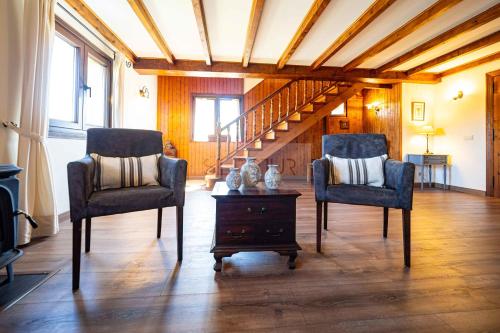 a living room with two chairs and a staircase at El Balcón Del Profesor By Silastur in Cereceda