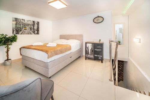 una camera da letto con un letto e un orologio sul muro di Apartment Porto with Terrace a Baška