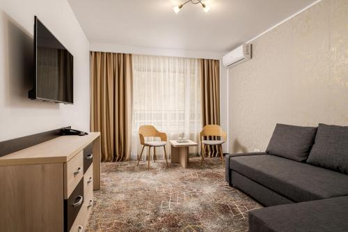 a living room with a couch and a table with chairs at Complex Balnear Cozia - Corp Oltul in Caciulata