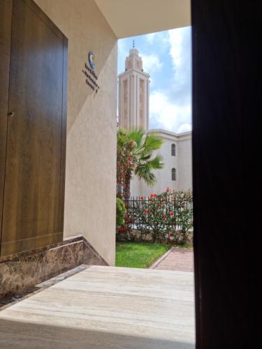 a view of a building with a clock tower at Appartement - Dar Bouazza spacieux avec piscine à Dar Bouazza in Dar Bouazza