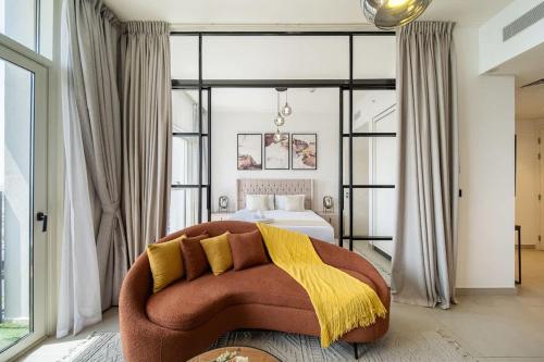 a bedroom with a bed and a couch with a yellow blanket at Airstay - Sophisticated 2BR - Dubai Hills Estate - Monthly Offer Available in Dubai