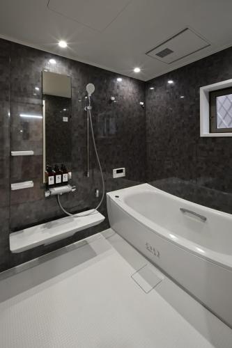 a bathroom with a bath tub and a shower at Otter Stay - Kogane in Nagoya