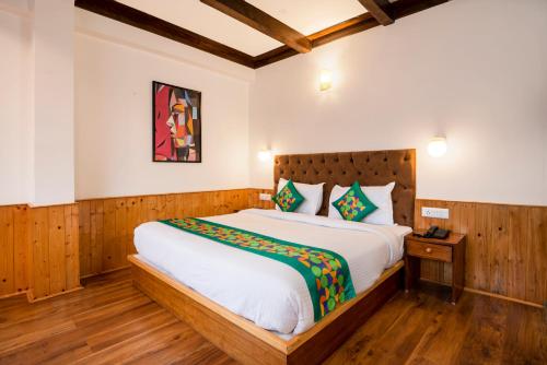 a bedroom with a large bed in a room at Treebo Premium Sattva With Mountain View in Manāli